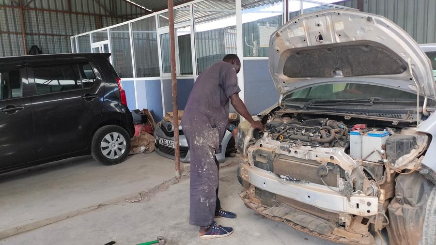 Mechanic inspecting a vehicle front end